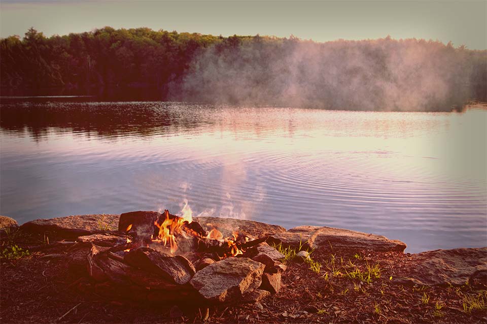 camp fire by a lake