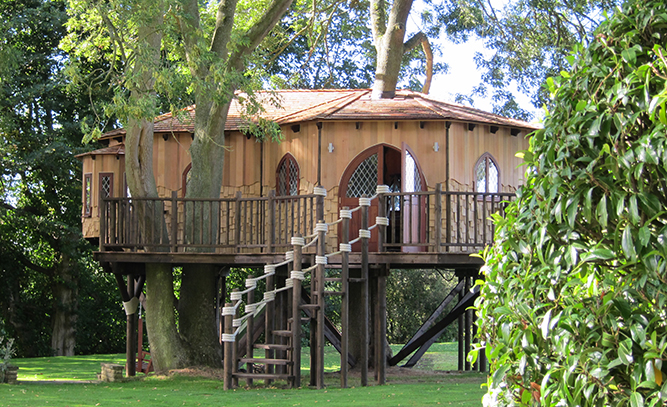 The Treehouse Office, built and designed by Blue Forest, has a winding wooden staircase with rope handrails.